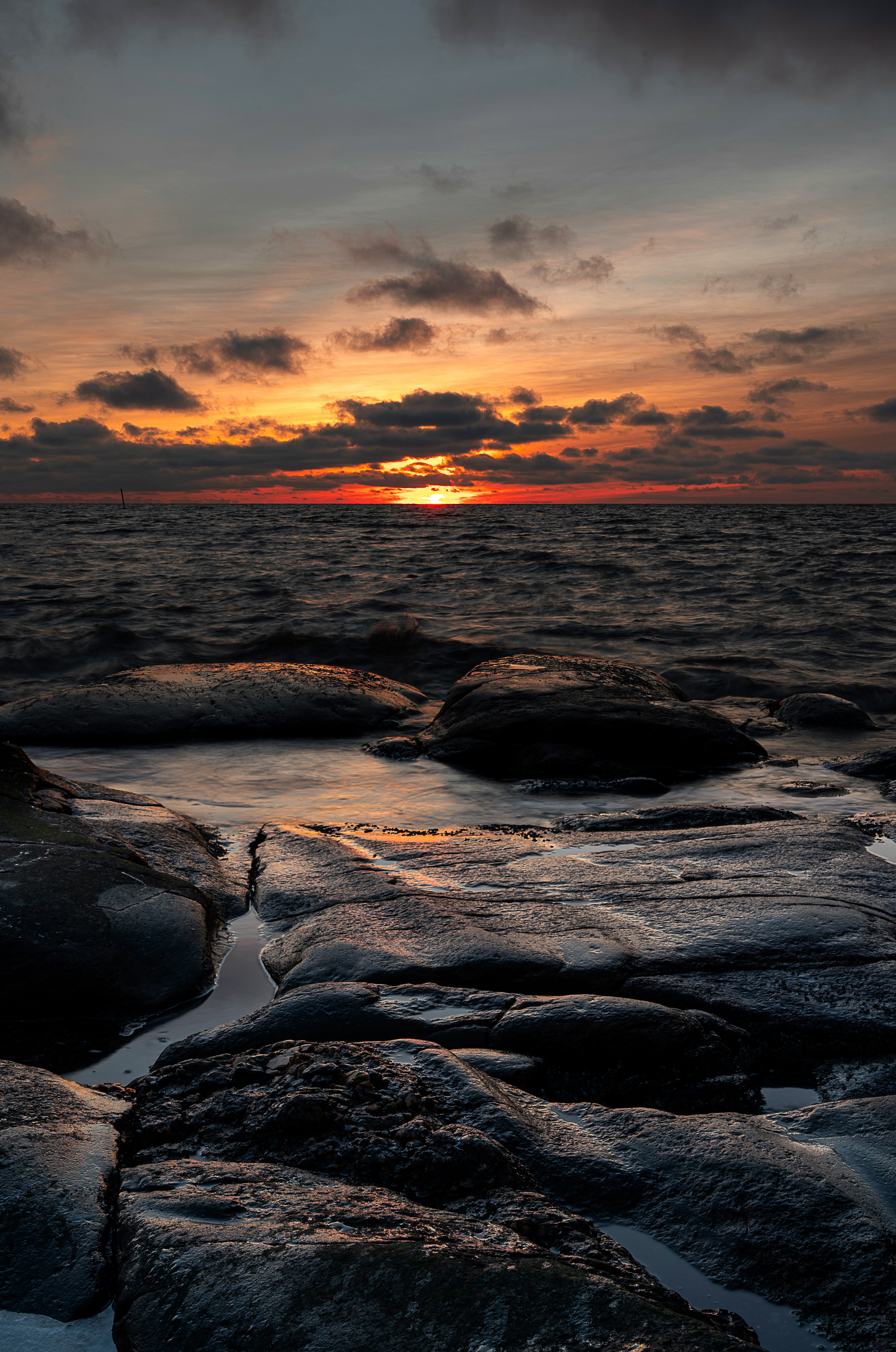 body of water under cloudy sky during sunset